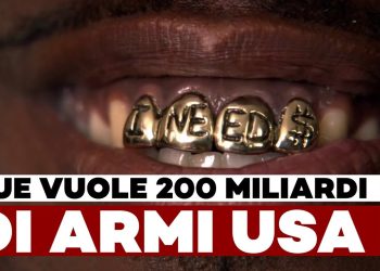 Bocca con in primo piano 4 denti d'oro incisi con la scritta I need $