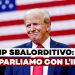 Donald Trump sorride con la bandiera degli USA alle spalle