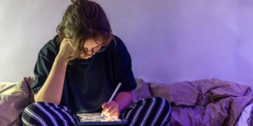 Studentessa seduta sul suo letto