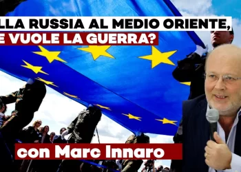 Folla che tiene una grande bandiera europea con Marc Innaro in primo piano