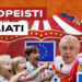 Tendone del circo. Bambini scherniscono Mario Monti e Carlo Calenda vestiti da clown in primo piano