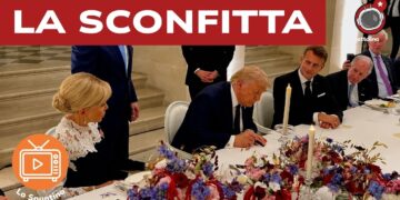 Donald Trump firma un documento al tavolo con Emmanuel Macron