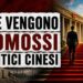 Un uomo cinese elegante di spalle sale una scala di velluto rosso verso la sede del Partito Comunista