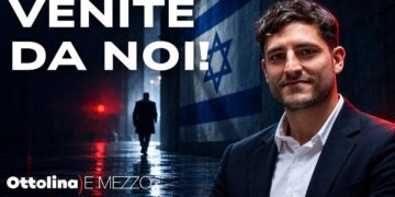 Persona di spalle cammina di notte in una strada israeliana. Michele Manfrin in primo piano
